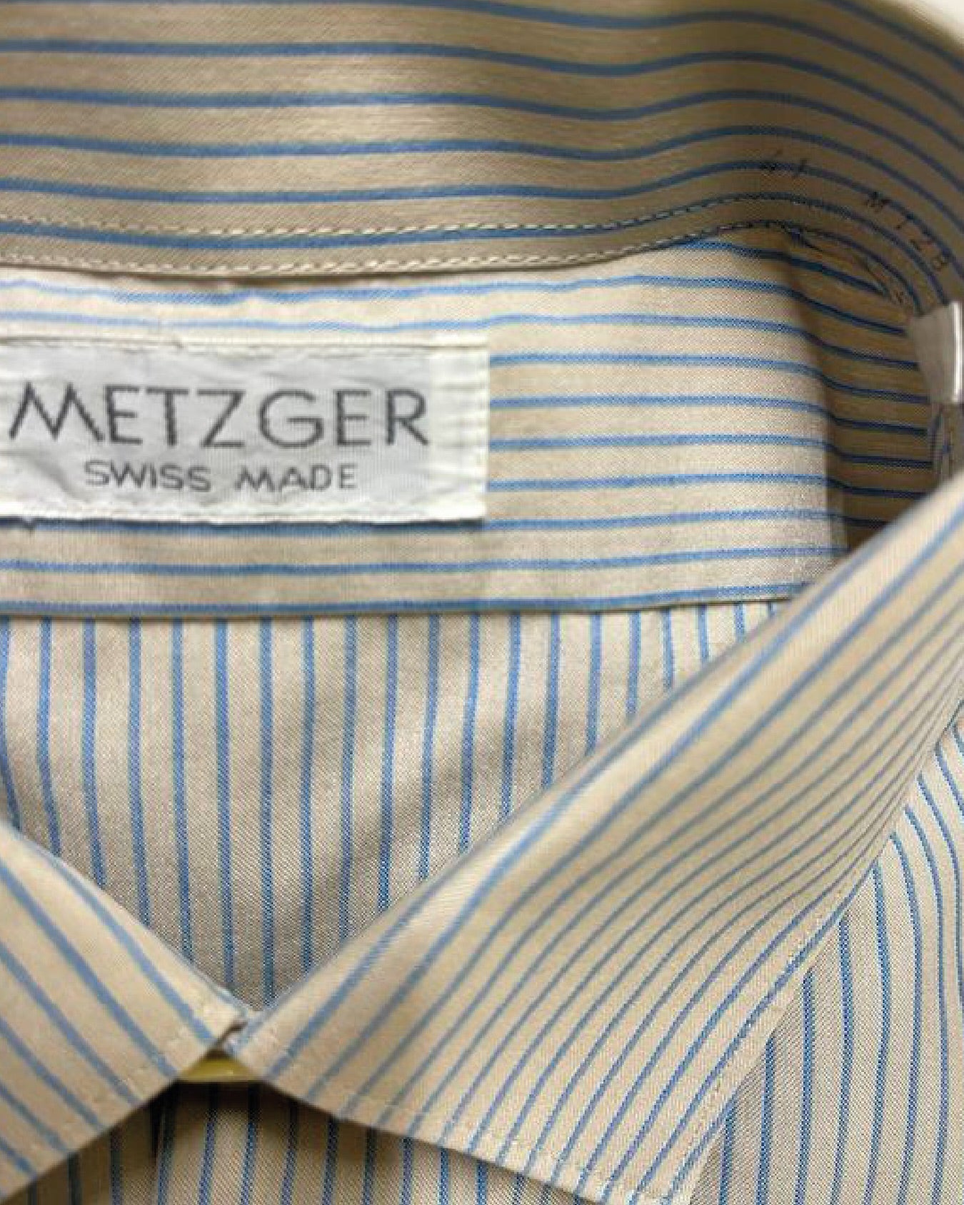 Close-up of a striped shirt with a Metzger label indicating Swiss made.