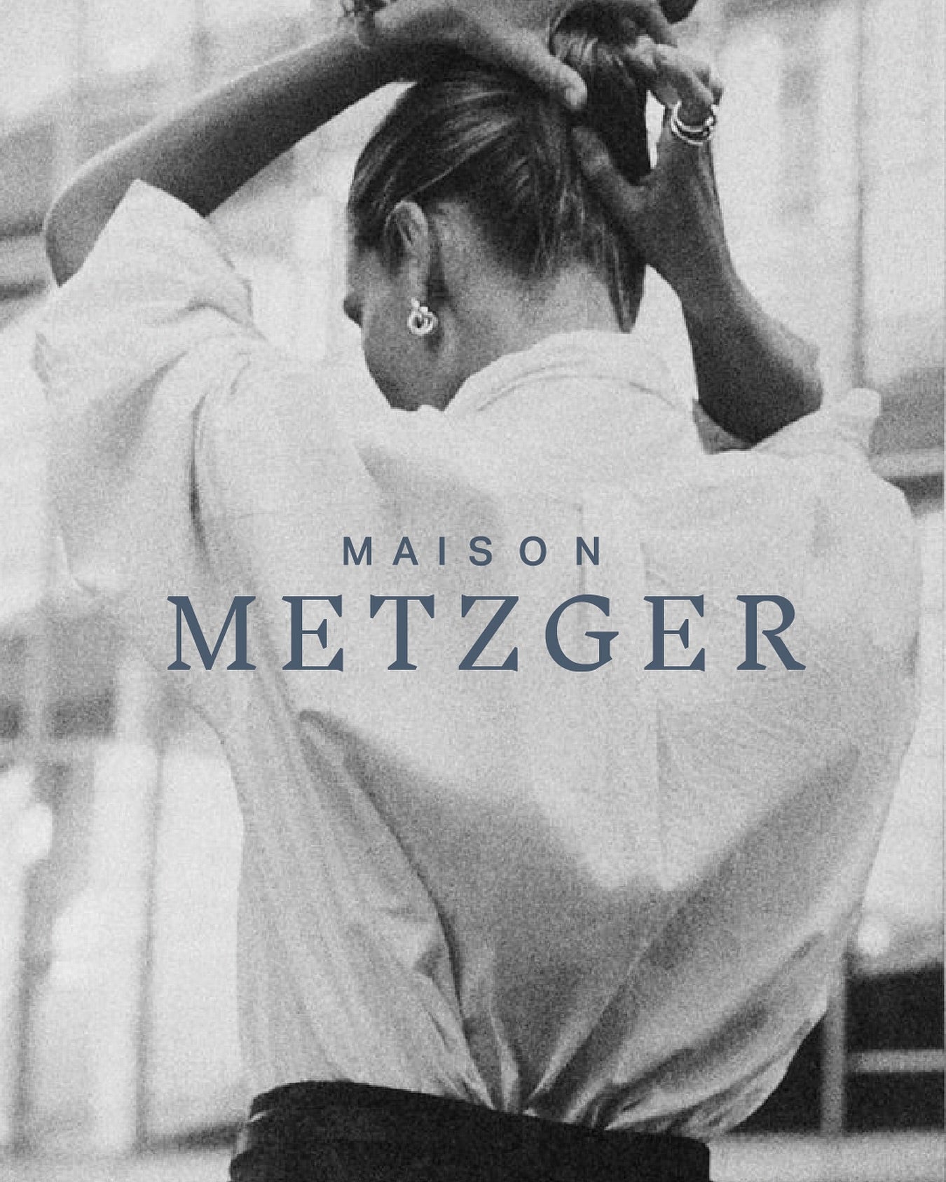 Person wearing a white shirt with 'MAISON METZGER' branding