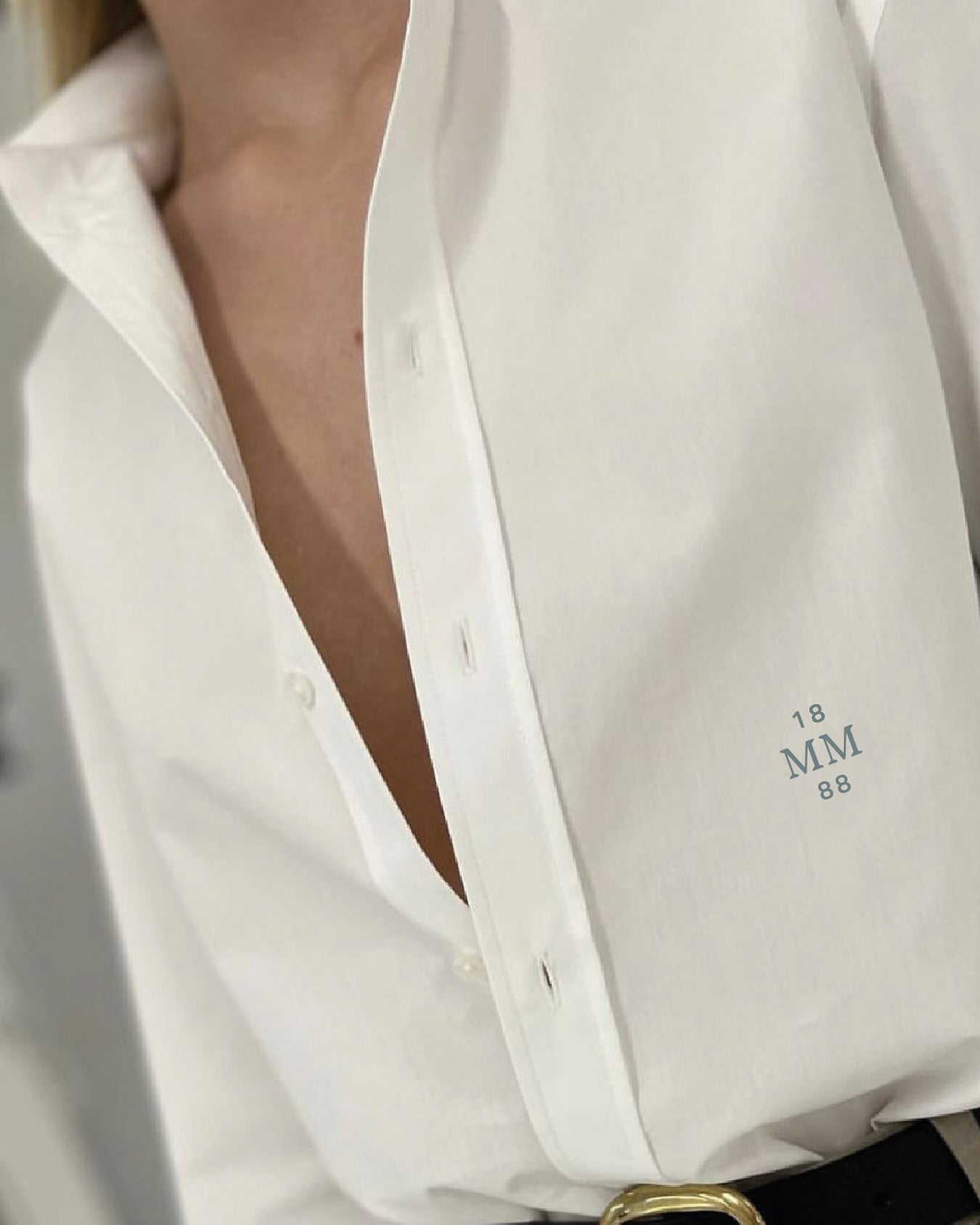 Close-up of a white shirt with a brand logo